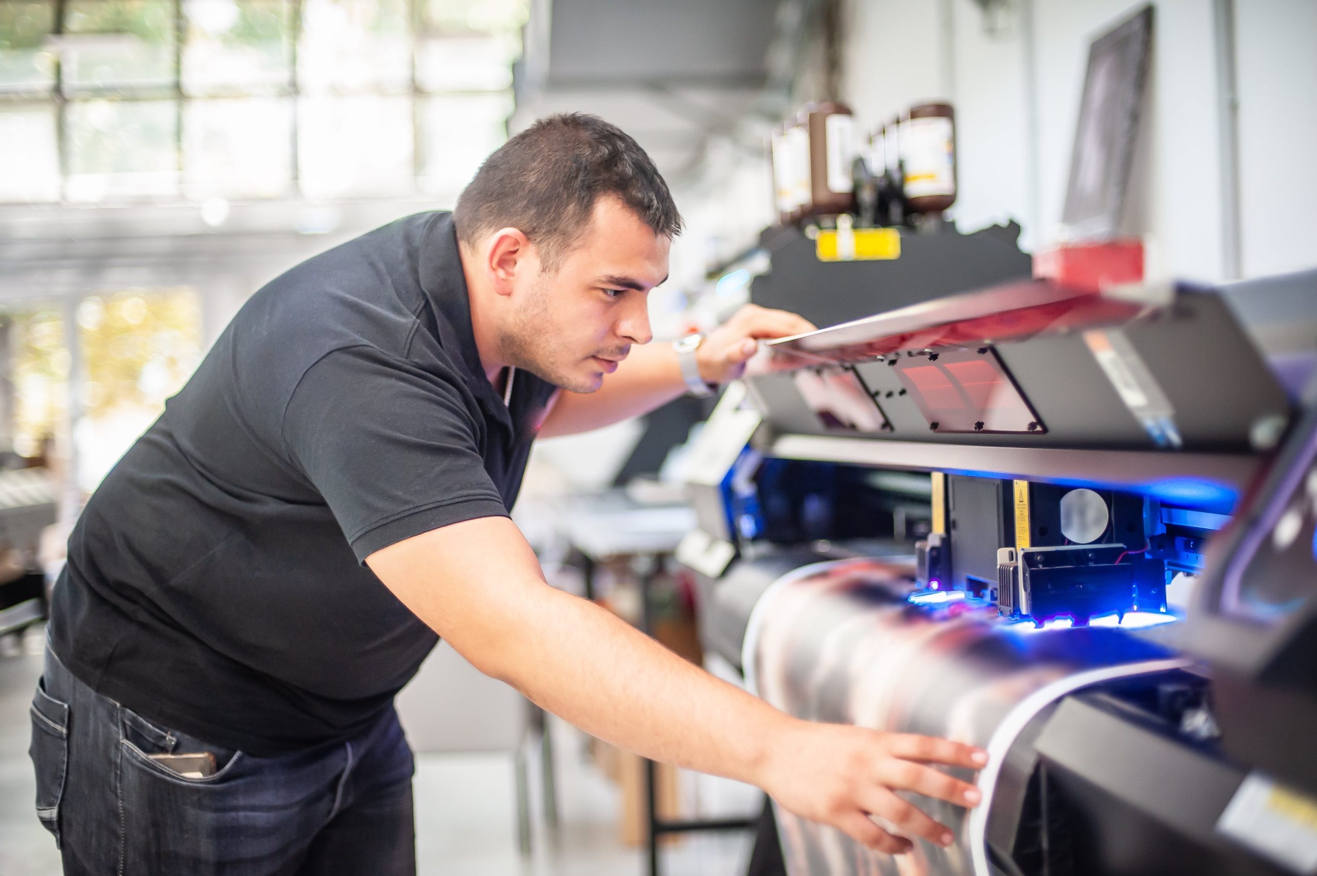 Man printing poster on large format printer